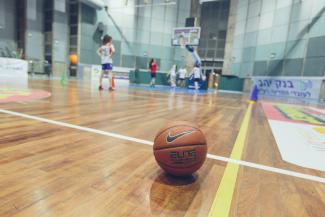 Members of PeacePlayers practice basketball on a local court.