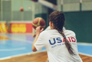 A girl gets ready to catch a basketball.