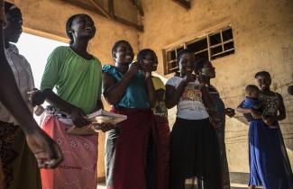 A group of women singing and smiling.