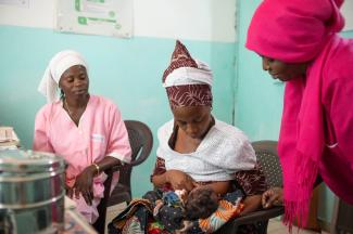 Djiba Balde breastfeeds her child, Aissatou Balde, in the health center of Saree Bilaly with the matrons, Aissatou Diarra (right) and Penda Balde (left) in Kolda region, Senegal.