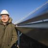 A man in a hard hat stands in front of a large conduit