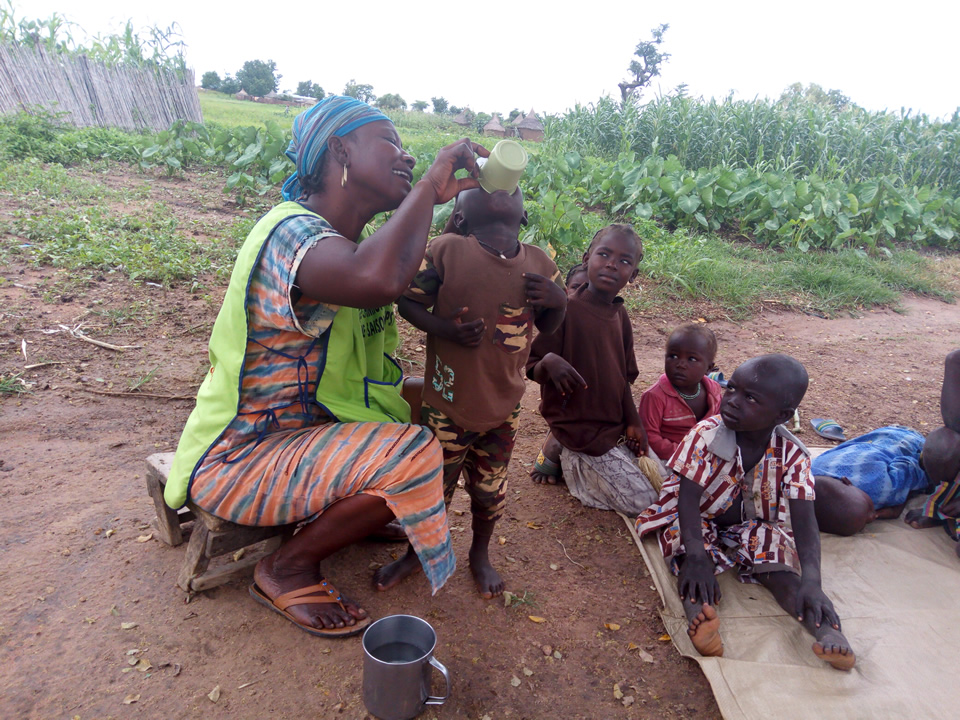 A health worker in Cameroon gives a child malaria medication. Photo credit: CRS