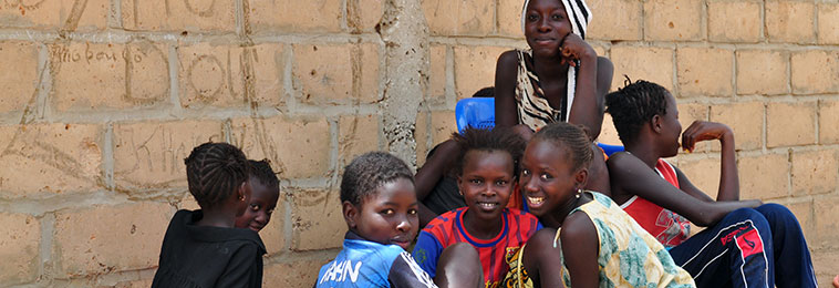 A group of teenage girls gather together to talk and smile in Senegal.