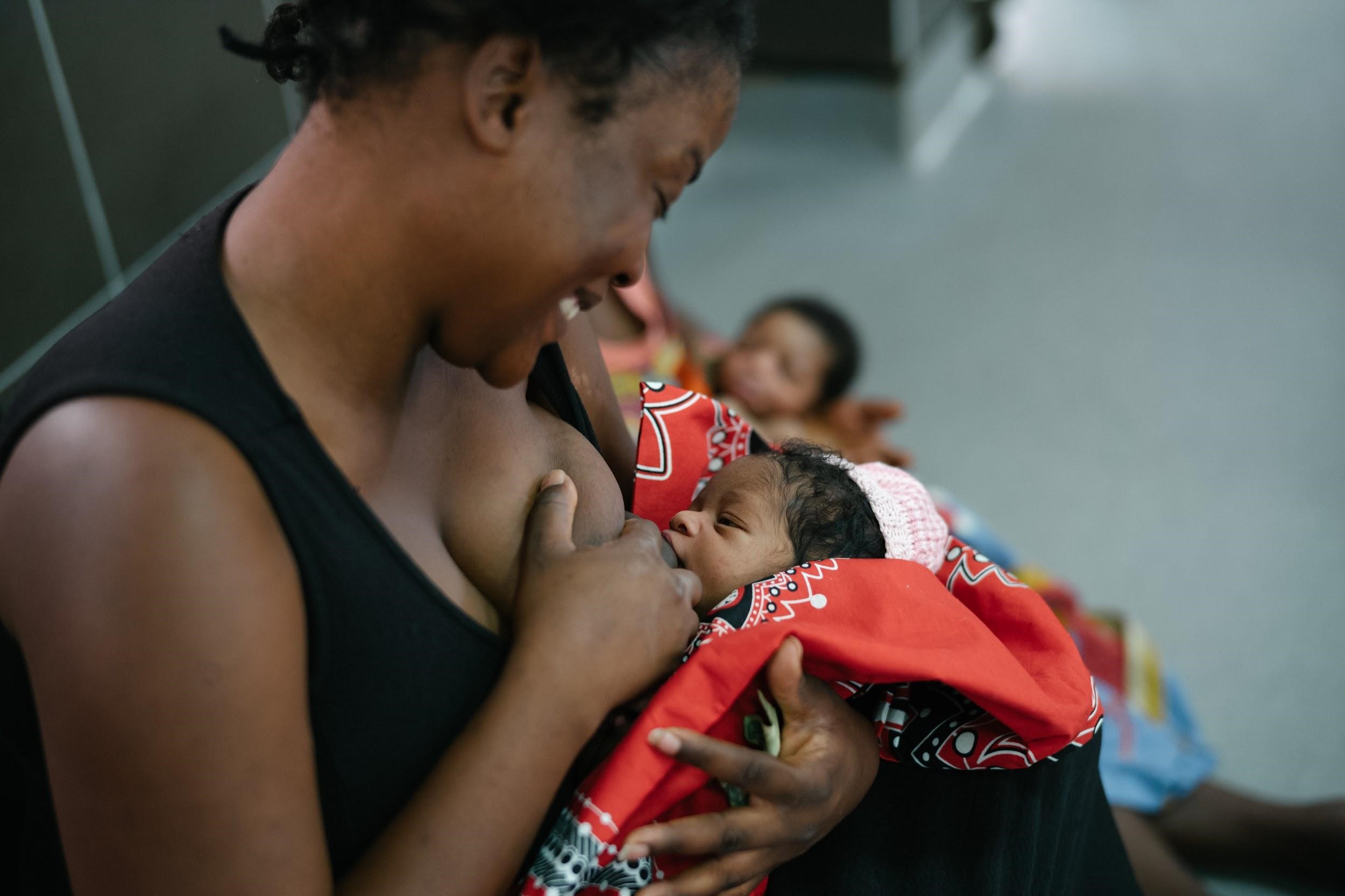 A woman breastfeeds her newborn.