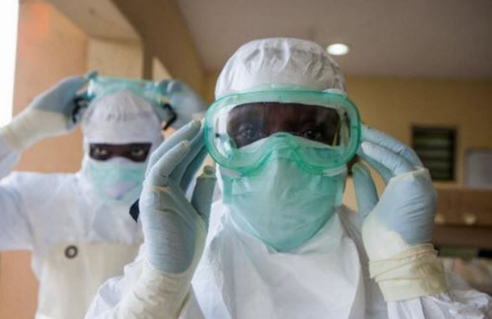 Photo of two female health workers in the DRC wearing protective suits. 