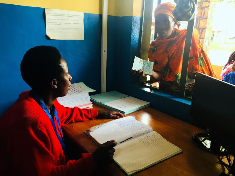 A client presents her community-based health insurance card to a Remera-Rukoma Hospital receptionist. Photo credit: Alanna Savage/MSH