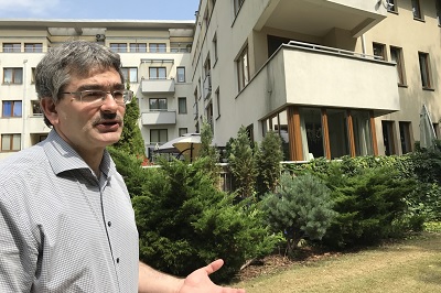 A man in front of apartment buildings